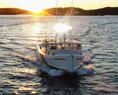 Front view of a boat on water during sunrise or sundown with lights on