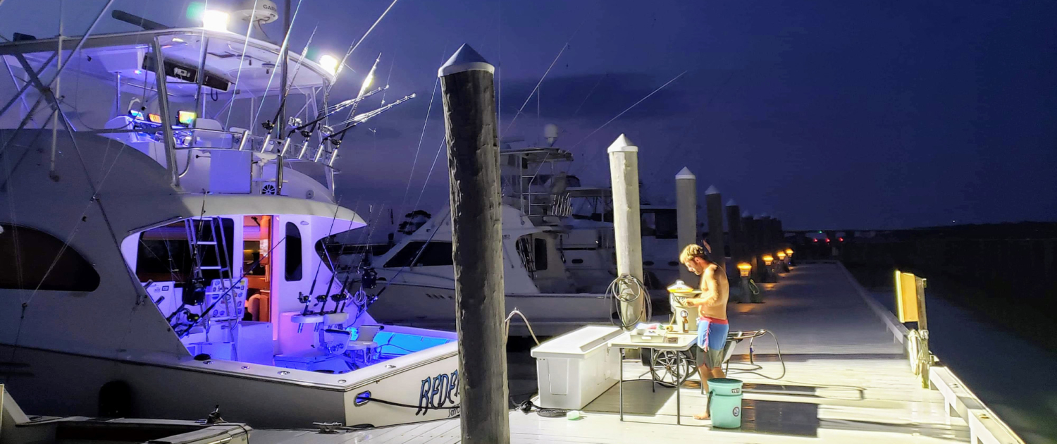 Fishing boat lights illuminating dock at night, side view