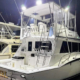 Side view of a fishing boat on a dock with bright lights